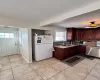 Kitchen featuring stainless steel dishwasher, a sink, freestanding refrigerator, and tasteful backsplash