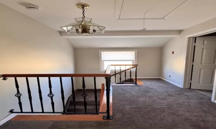 Stairs with attic access, lofted ceiling, carpet flooring, and baseboards