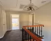 Corridor with visible vents, dark carpet, an inviting chandelier, an upstairs landing, and baseboards