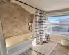 Full bath with baseboards and shower / bathtub combination with curtain