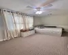 Unfurnished bedroom with ceiling fan, carpet flooring, and visible vents