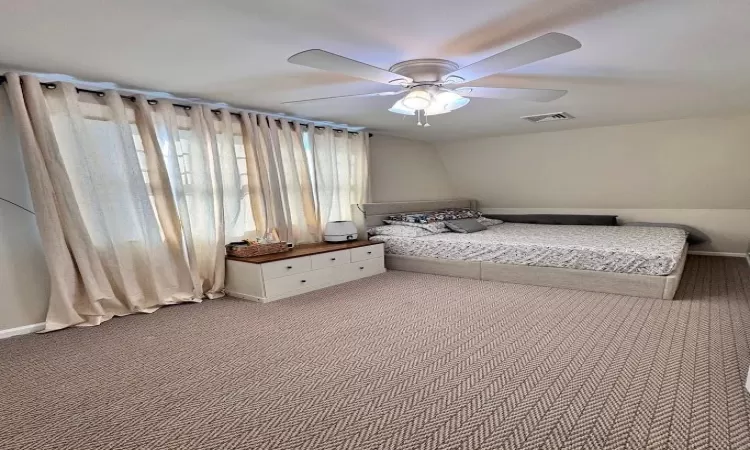 Unfurnished bedroom with ceiling fan, carpet flooring, and visible vents