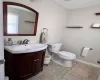 Bathroom with baseboards, vanity, toilet, and tile patterned floors