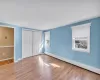 Unfurnished bedroom with light wood-type flooring, multiple windows, and a baseboard radiator