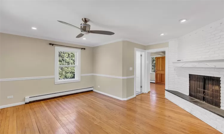 Unfurnished Den  , a fireplace, light wood flooring, and crown molding