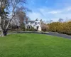 Shingle-style home featuring a chimney and a front lawn