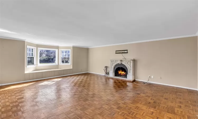 Unfurnished living room featuring crown molding, a fireplace,