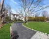 Shingle-style home featuring a chimney and a front yard