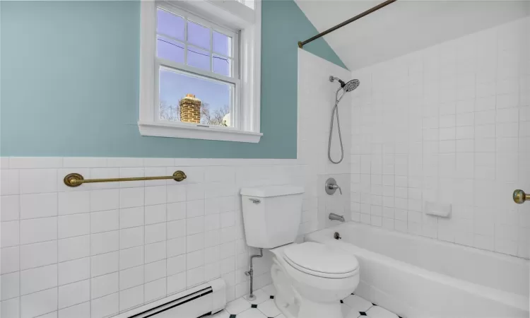 Full bathroom with shower / bathtub combination, a baseboard radiator, a wainscoted wall, and tile walls