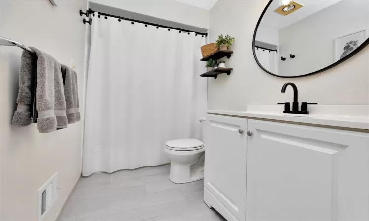 Full bath featuring visible vents, vanity, and toilet