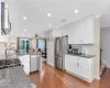 Kitchen with ornamental molding, appliances with stainless steel finishes, dark wood-type flooring, and decorative backsplash