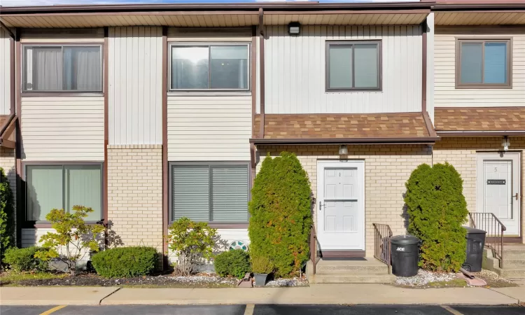 Multi unit property featuring brick siding and roof with shingles