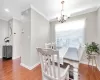 Dining area with a notable chandelier, crown molding, baseboards, and wood finished floors