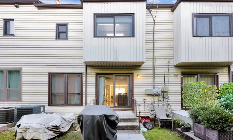 Rear view of house featuring cooling unit