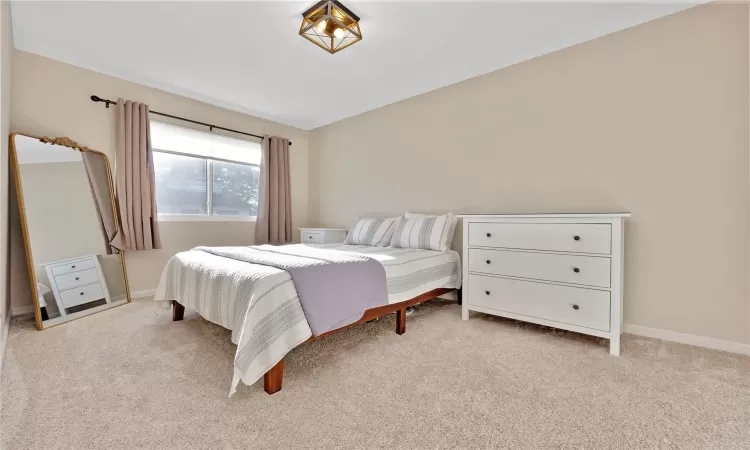 Carpeted bedroom featuring baseboards