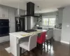 Kitchen with island range hood, a sink, black appliances, and open shelves