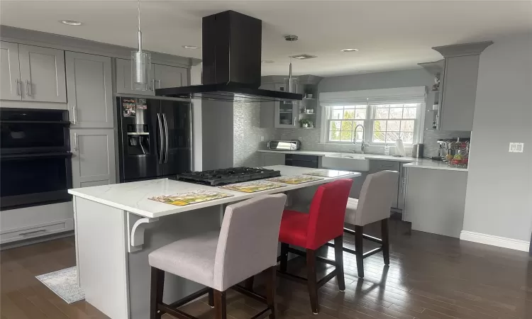 Kitchen with island range hood, a sink, black appliances, and open shelves