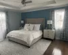 Bedroom with ornamental molding, multiple windows, wood finished floors, and visible vents