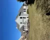 Rear view of house featuring a chimney and a lawn