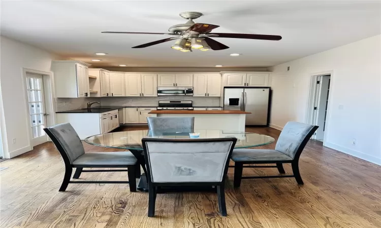 Kitchen featuring backsplash, white cabinetry, stainless steel appliances, and a sink