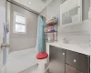 Bathroom featuring tile walls, visible vents, toilet, shower / tub combo, and vanity