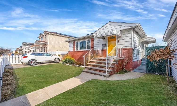 Bungalow-style house featuring fence, a front lawn, and brick siding