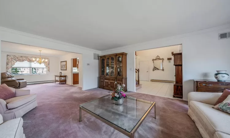 Foyer featuring light tile patterned floors, stairway, baseboard heating, and a high ceiling