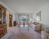 Carpeted living room featuring ornamental molding and visible vents