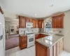 Kitchen with a peninsula, white appliances, a fireplace, and brown cabinets