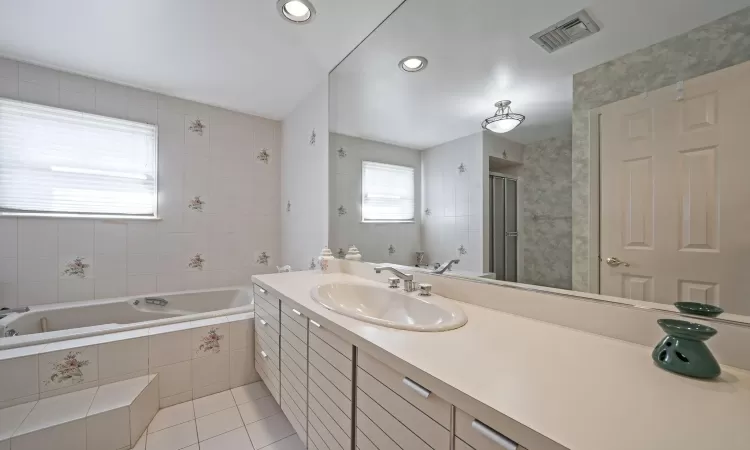 Carpeted bedroom with a baseboard heating unit and ceiling fan