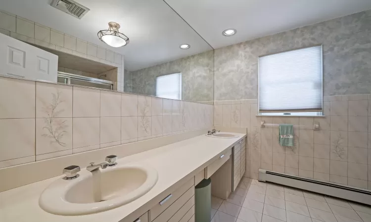 Bedroom featuring ceiling fan, baseboard heating, baseboards, and light colored carpet