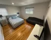 Bedroom with a baseboard radiator, wood finished floors, and recessed lighting