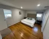 Bedroom with baseboard heating, wood finished floors, visible vents, and recessed lighting