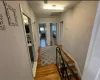 Hallway featuring baseboards, visible vents, an upstairs landing, and wood finished floors