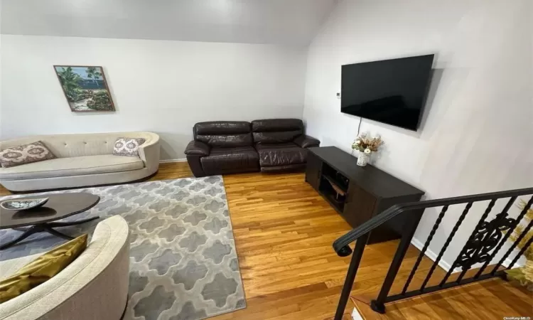 Living room featuring vaulted ceiling and wood finished floors