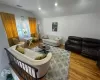 Living room with recessed lighting, visible vents, vaulted ceiling, and wood finished floors