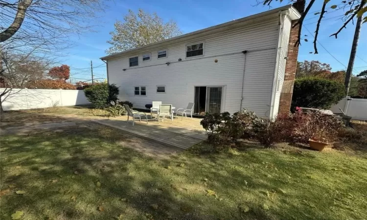 Rear view of house featuring a yard and fence