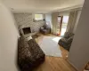 Living room with a brick fireplace, brick wall, baseboards, and wood finished floors