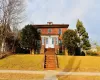 American foursquare style home featuring brick siding and a front yard