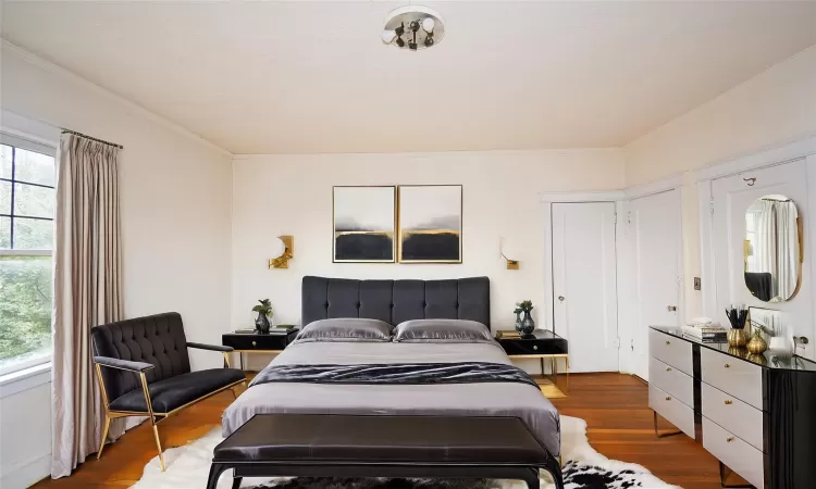 Bedroom with crown molding and wood finished floors