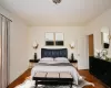 Bedroom featuring ornamental molding, wood finished floors, and baseboards