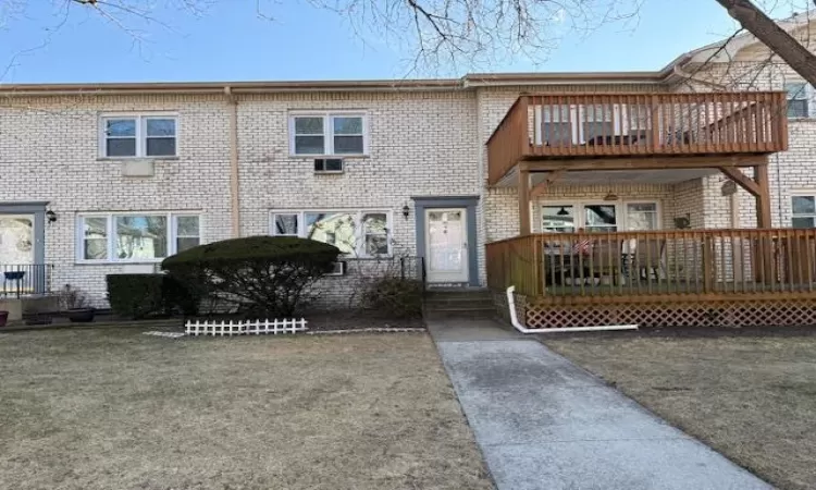 View of property featuring a deck and brick siding