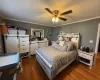 Bedroom with crown molding, ceiling fan, and dark wood-type flooring