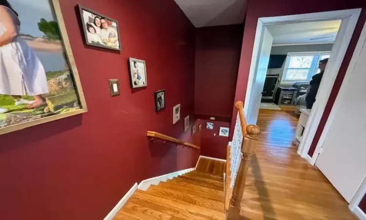 Stairs featuring wood finished floors