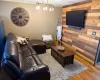 Living room featuring wood walls, crown molding, and wood finished floors