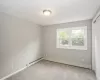 Unfurnished room with carpet and a baseboard heating unit