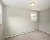 Empty room with carpet floors, a baseboard radiator, and baseboards