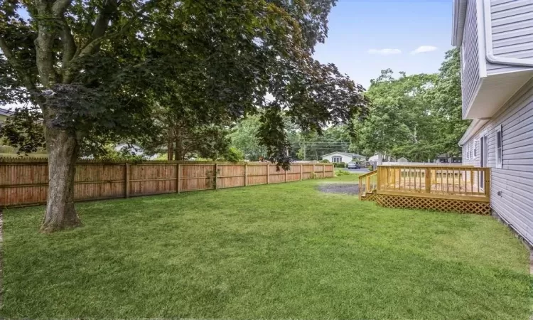 View of yard featuring a fenced backyard and a deck