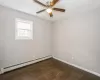 Unfurnished room with a ceiling fan, a baseboard radiator, baseboards, and wood finished floors