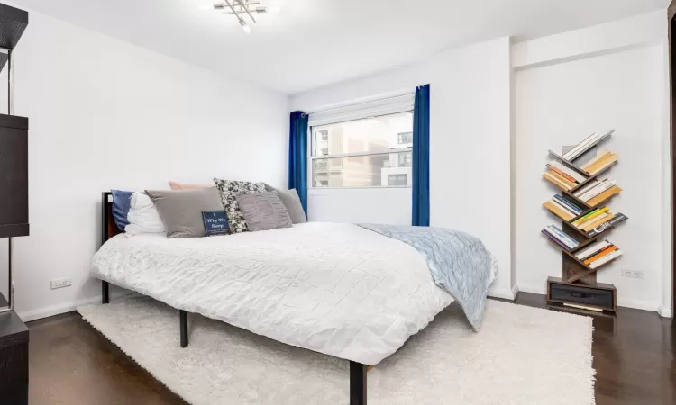 Bedroom featuring baseboards and dark wood-style flooring